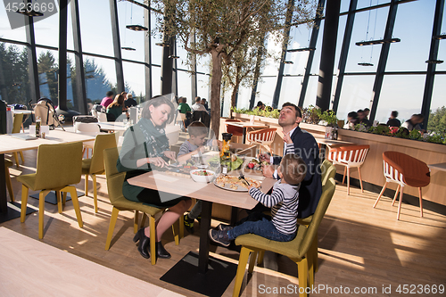 Image of Young parents enjoying lunch time with their children