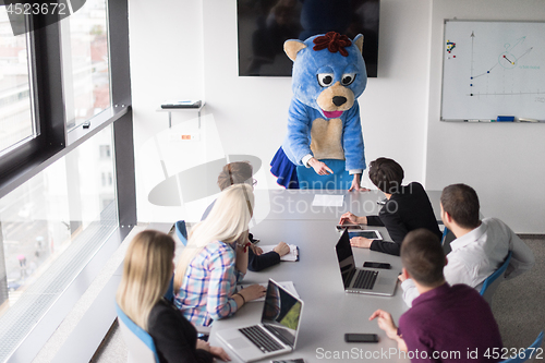 Image of boss dresed as bear having fun with business people in trendy of