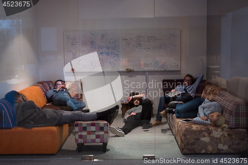 Image of software developers sleeping on sofa in creative startup office