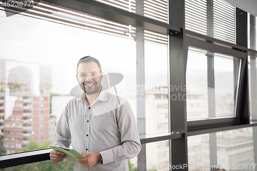 Image of Businessman Using Tablet In Office Building by window