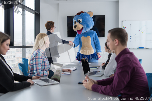 Image of boss dresed as bear having fun with business people in trendy of