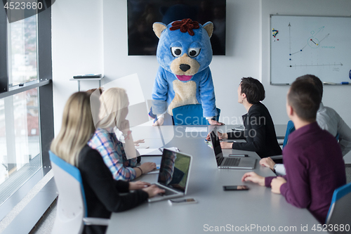 Image of boss dresed as bear having fun with business people in trendy of