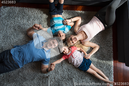 Image of happy family lying on the floor