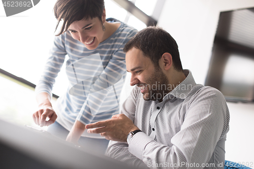 Image of Two Business People Working With Tablet in startup office