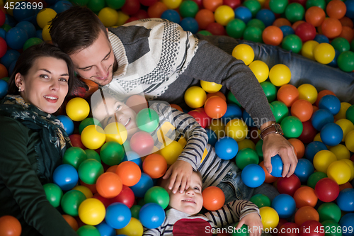 Image of young parents with kids in a children\'s playroom