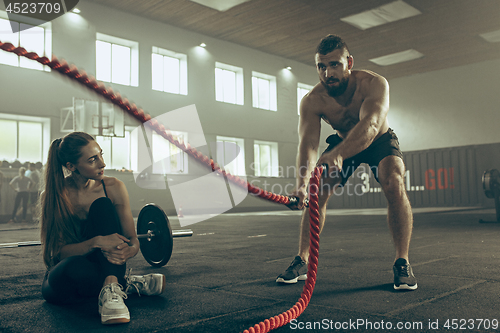 Image of Men with battle rope battle ropes exercise in the fitness gym.