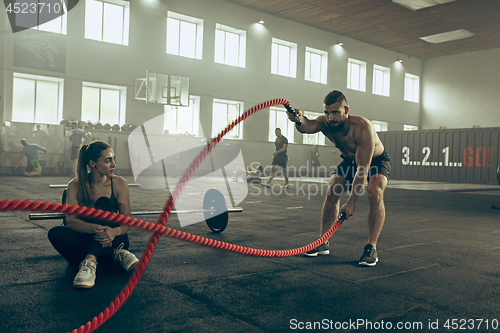 Image of Men with battle rope battle ropes exercise in the fitness gym.