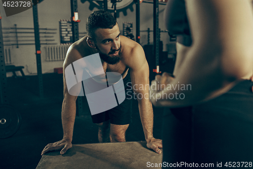 Image of Man during exercises in the fitness gym. CrossFit.