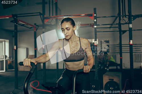 Image of woman during exercises in the fitness gym. CrossFit.