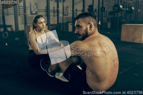 Image of Man and woman during exercises in the fitness gym. CrossFit.