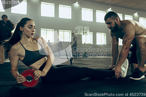 Image of Fit young woman lifting barbells working out in a gym