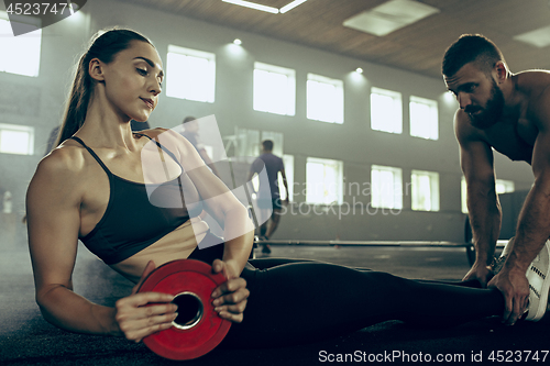 Image of Fit young woman lifting barbells working out in a gym