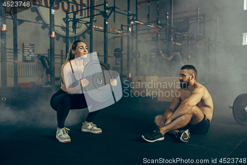 Image of Fit young woman lifting barbells working out in a gym