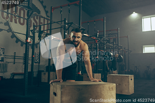 Image of Man during exercises in the fitness gym. CrossFit.