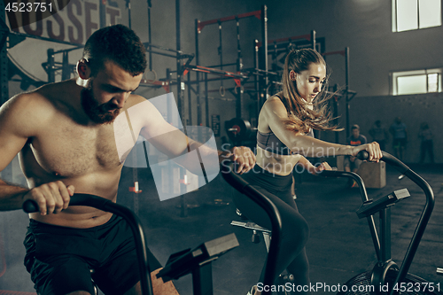 Image of Man and woman during exercises in the fitness gym. CrossFit.