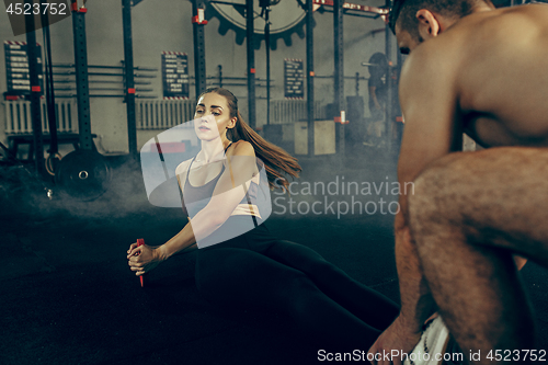 Image of Fit young woman lifting barbells working out in a gym