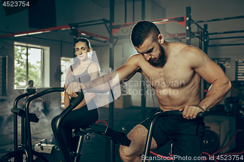 Image of Man and woman during exercises in the fitness gym. CrossFit.