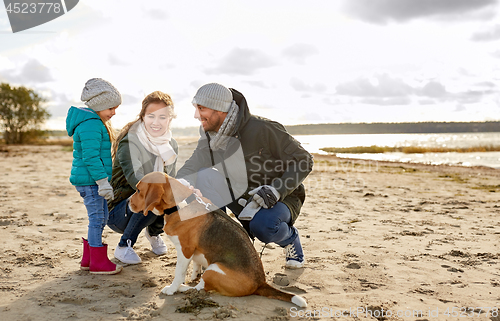 Image of happy family with beagle dog on beach