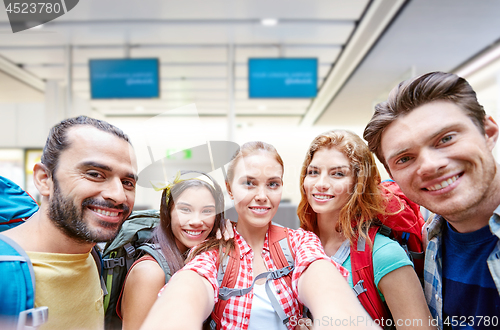 Image of friends or tourists taking selfie over airport