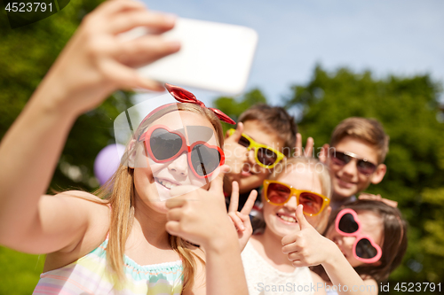 Image of kids taking selfie and showing thumbs up at park