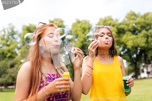 Image of teenage girls blowing bubbles at summer park