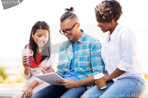 Image of students with notebook and takeaway drinks