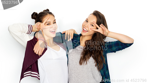 Image of happy teenage girls hugging and showing peace sign