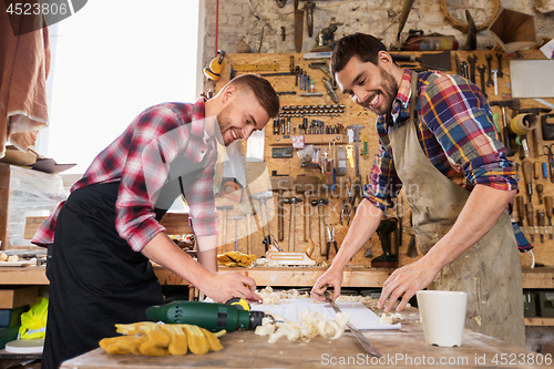 Image of carpenters with ruler and blueprint at workshop