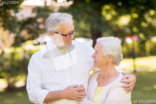 Image of happy senior couple hugging at summer park