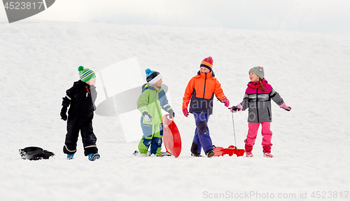 Image of happy little kids with sleds sledging in winter