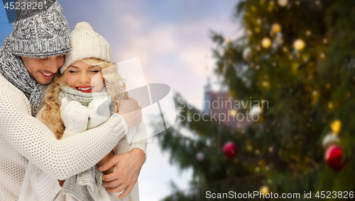 Image of happy couple hugging over christmas tree