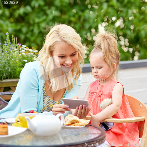 Image of mother and baby daughter with smartphone at cafe