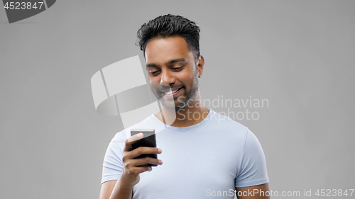 Image of happy indian man using smartphone