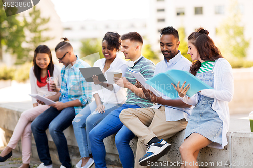 Image of international students with notebooks outdoors