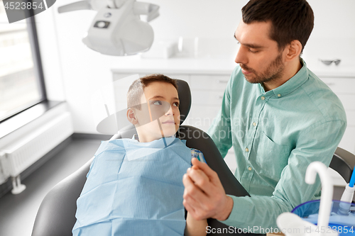 Image of father supporting son at dental clinic