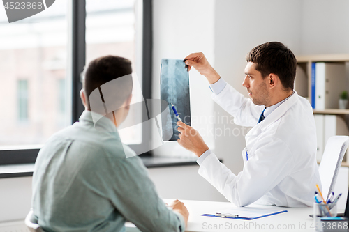 Image of doctor showing x-ray to patient at hospital