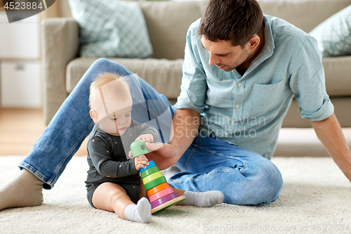 Image of father playing with little baby daughter at home