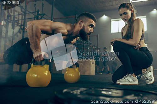 Image of Fit young man lifting barbells working out in a gym