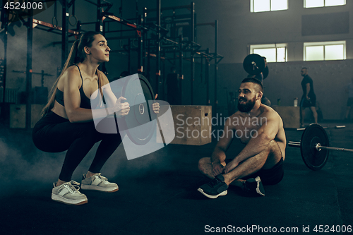 Image of Fit young woman lifting barbells working out in a gym