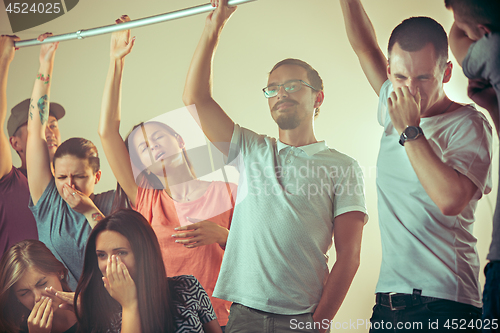 Image of Sweaty armpits. Sweaty man. Bus. Public transport. The unhappy people near man