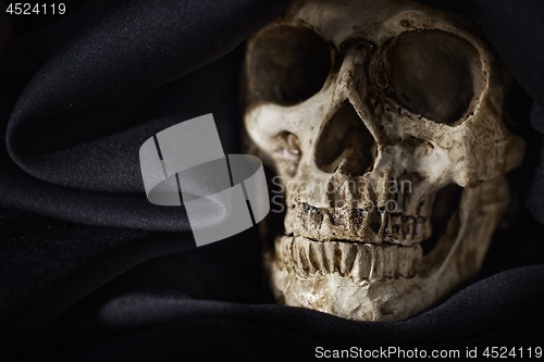 Image of Closeup photo an old skull covered in black robe
