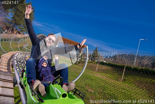 Image of young father and son driving alpine coaster