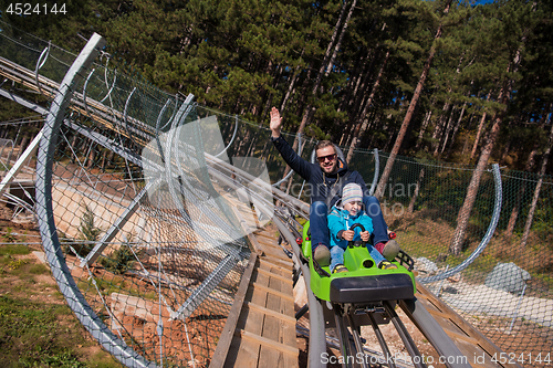 Image of young father and son driving alpine coaster