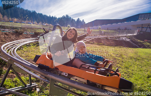 Image of young mother and son driving alpine coaster