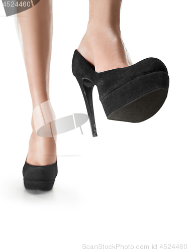 Image of Tanned female legs in high heels isolated on white background.