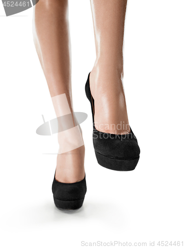Image of Tanned female legs in high heels isolated on white background.