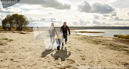 Image of happy family running along autumn beach