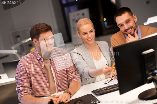 Image of business team with computer working late at office