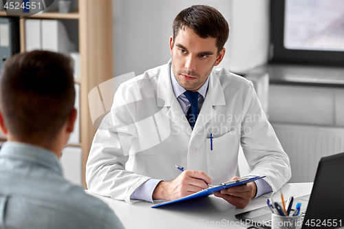 Image of doctor with clipboard and male patient at hospital