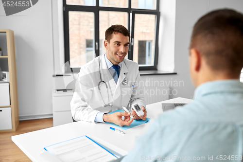 Image of doctor with glucometer and patient at hospital